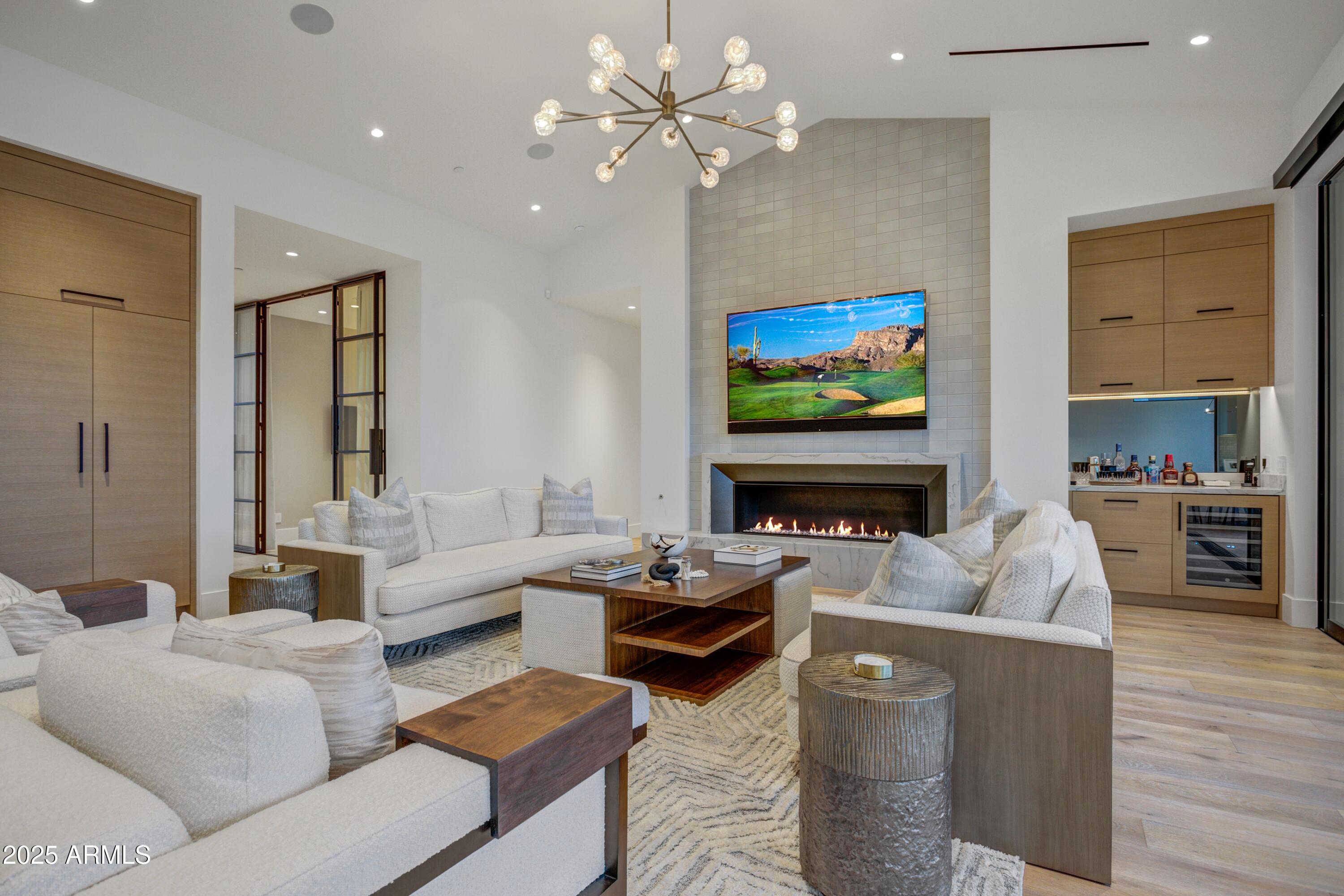 6930 East Cactus Wren Road Paradise Valley, AZ 85253 - Photo 7 of 26 a living room with furniture a fireplace and a flat screen tv