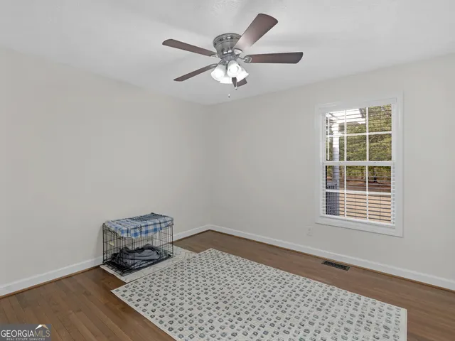 a view of wooden floor in an empty room with a window