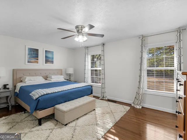 a living room with hardwood floor and a ceiling fan