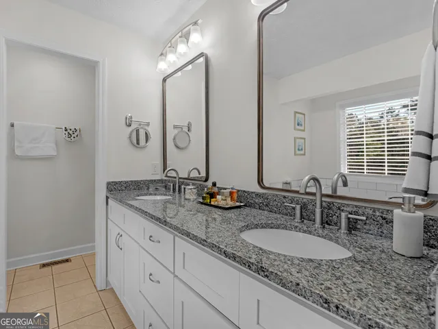 a bathroom with a granite countertop sink and a mirror