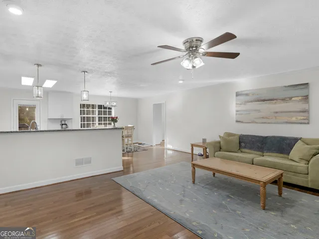 a living room with furniture and kitchen view