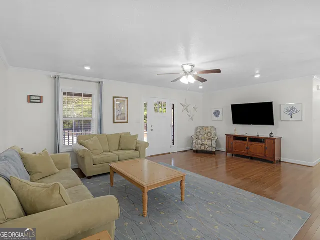 a living room with furniture a flat screen tv and a window