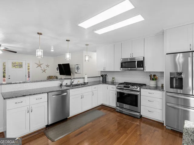 a kitchen with stainless steel appliances granite countertop a sink and stove top oven