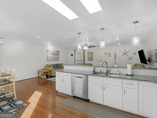 a large white kitchen with a sink and dishwasher