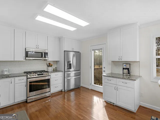 a kitchen with white cabinets and stainless steel appliances