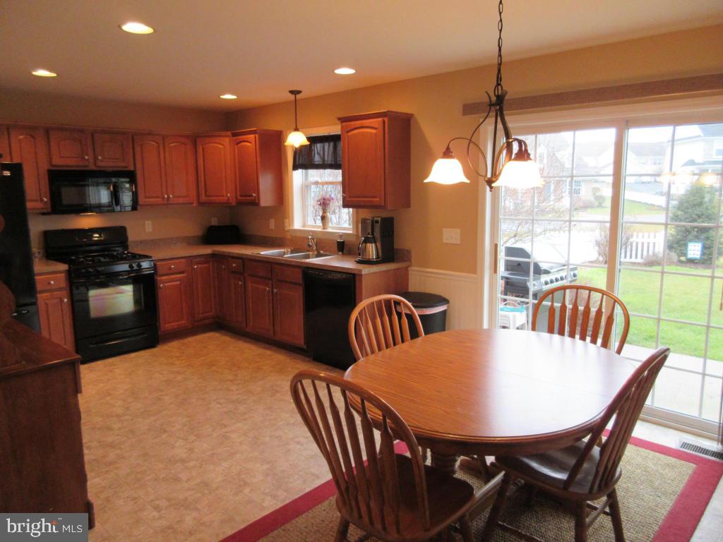 760 Wallingford Road Lititz, PA 17543 - Photo 5 of 16 a kitchen with stainless steel appliances granite countertop a stove a refrigerator a kitchen island a table and chairs