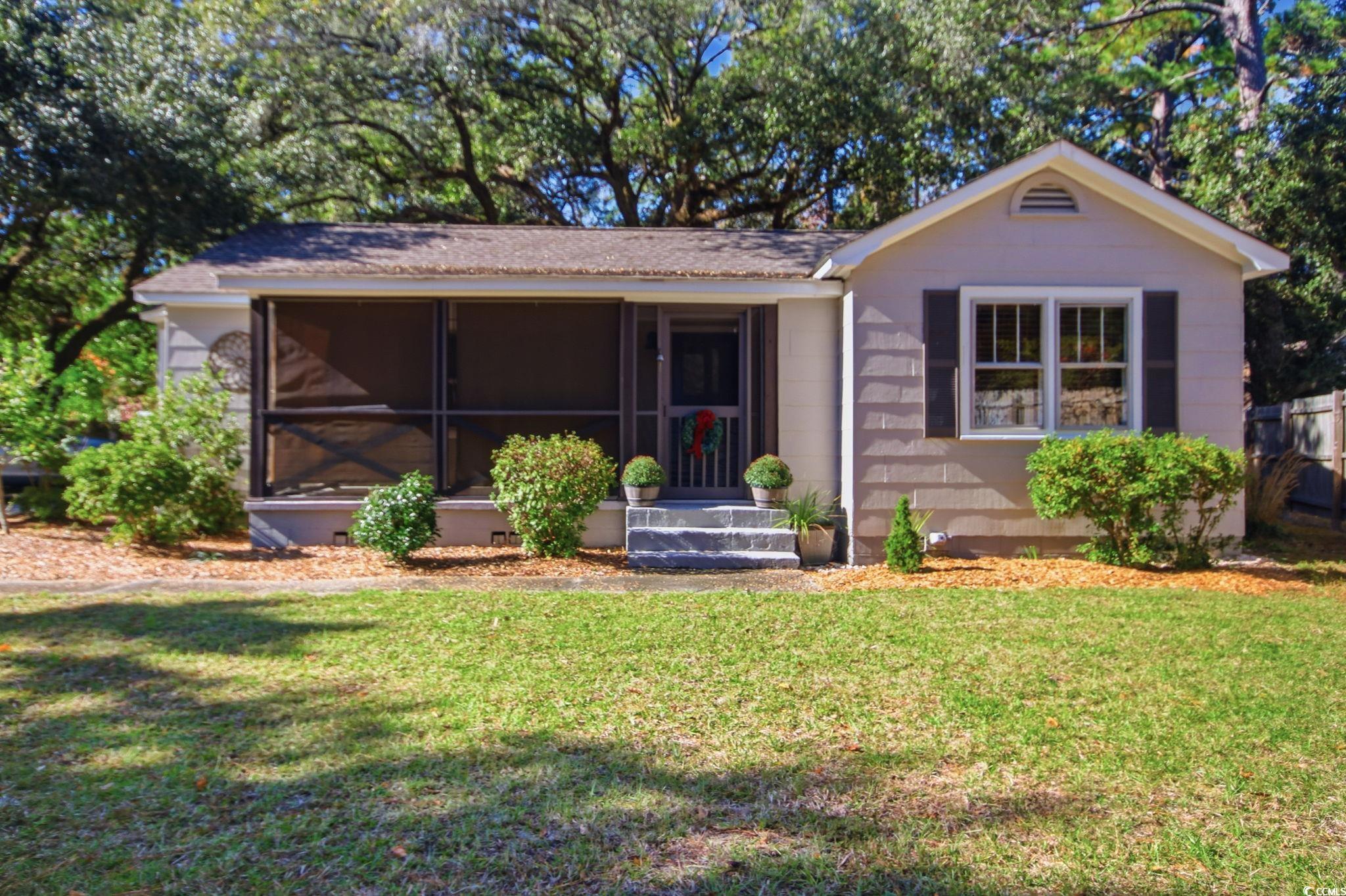 Rear view of property featuring a sunroom and a lawn