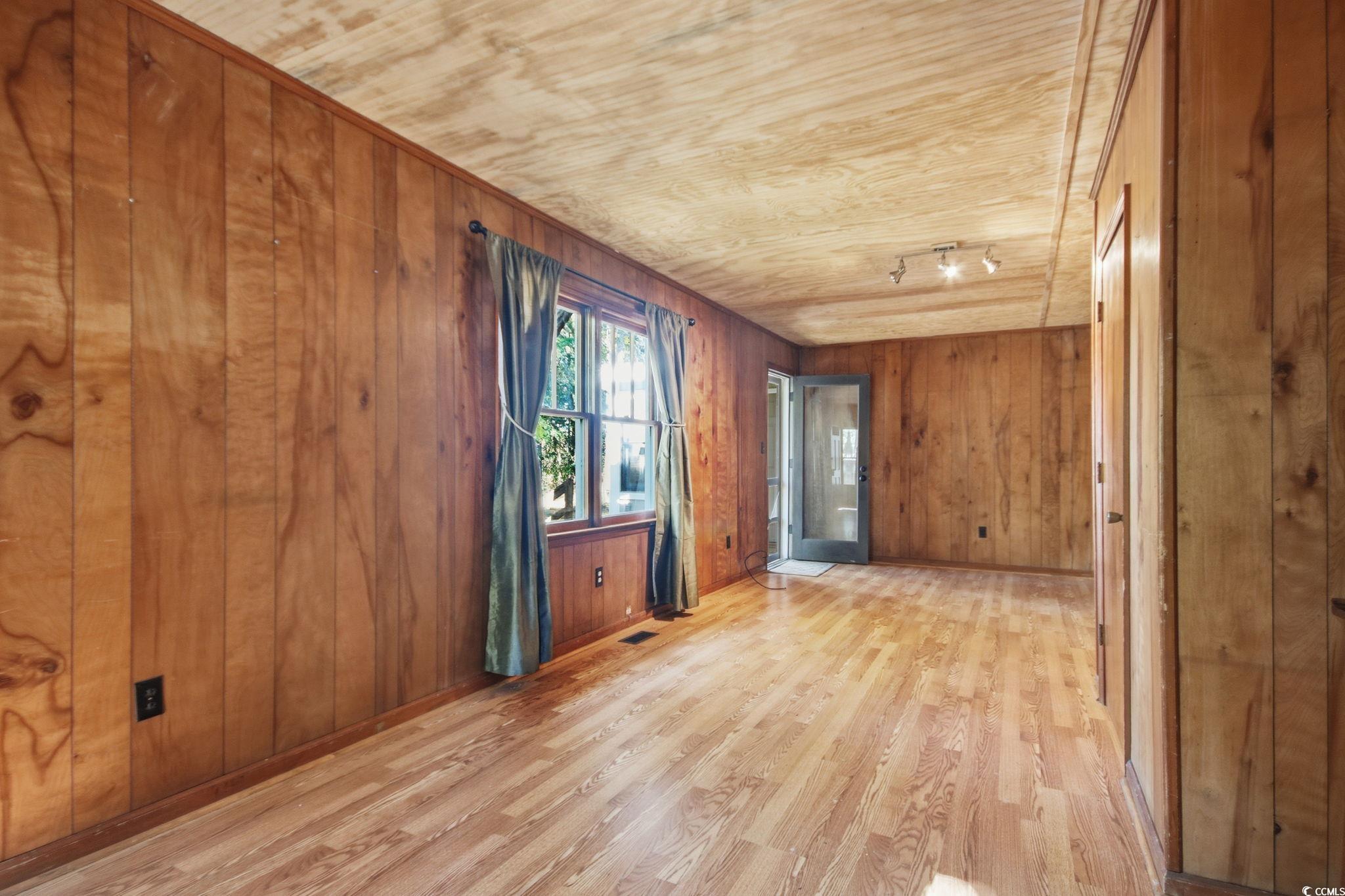 2206 Beck Street Georgetown, SC 29440 - Photo 17 of 36 Spare room featuring light wood-type flooring and wood walls