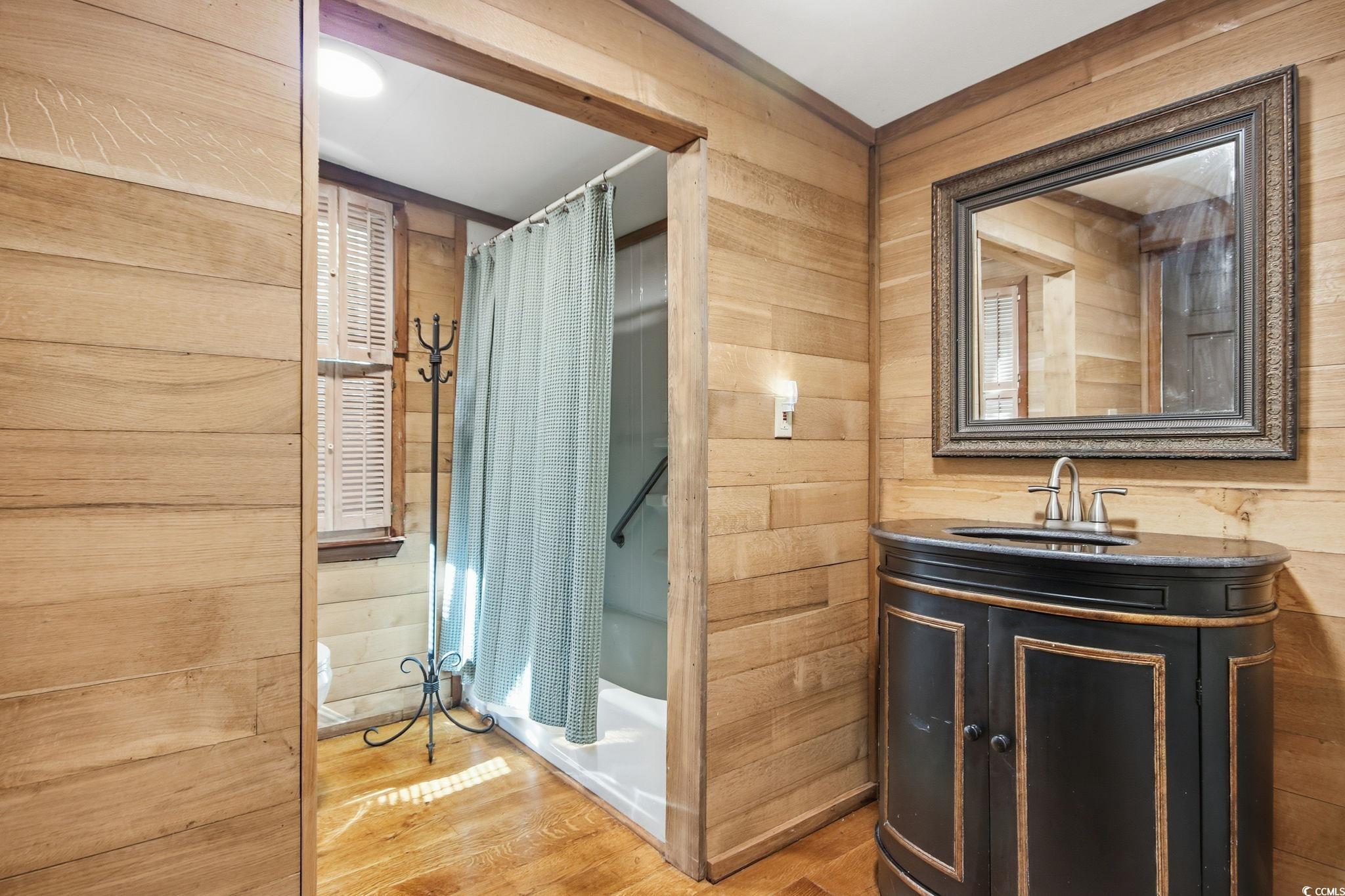 2206 Beck Street Georgetown, SC 29440 - Photo 20 of 36 Full bath with wood walls, vanity, and wood finished floors
