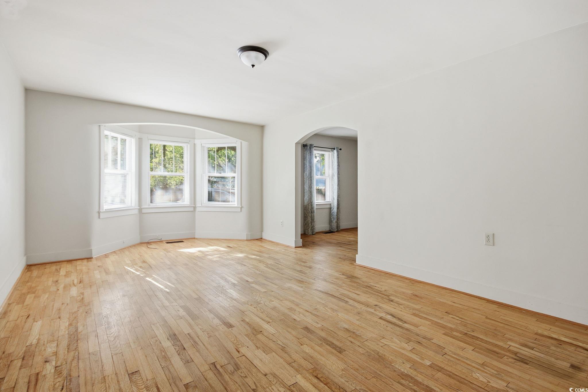 2206 Beck Street Georgetown, SC 29440 - Photo 7 of 36 Empty room with arched walkways and light wood-type flooring