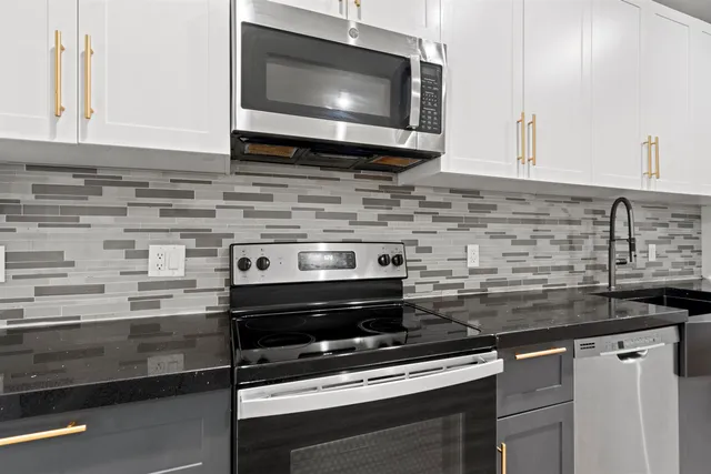 a kitchen with microwave stove and cabinets