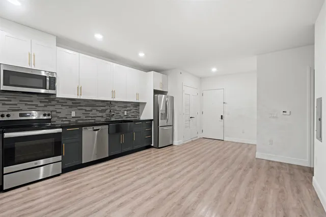 a kitchen with stainless steel appliances kitchen island granite countertop a stove a sink and a microwave