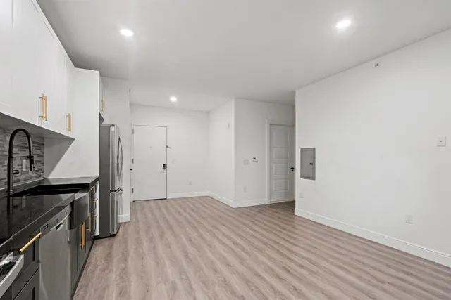 a view of a kitchen with a sink and a refrigerator