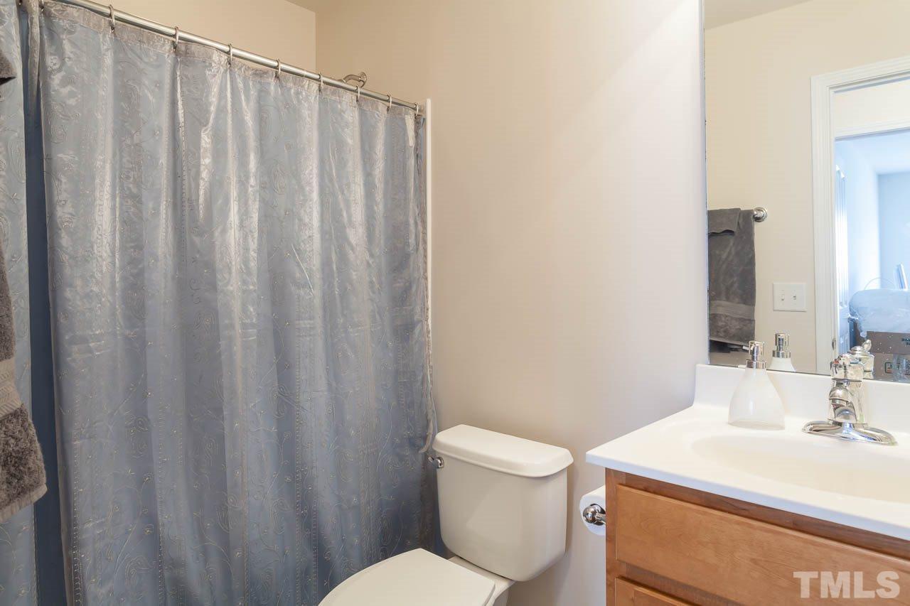 8712 Redcrest Place Raleigh, NC 27617 - Photo 14 of 15 a bathroom with a sink a toilet a mirror and shower curtain