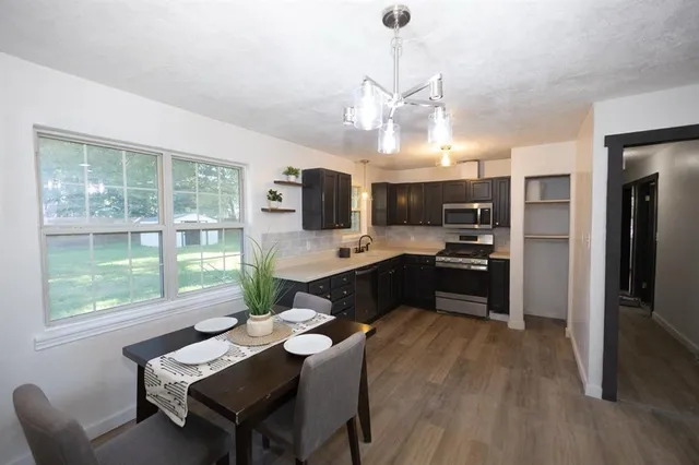 a kitchen with a table chairs refrigerator and microwave