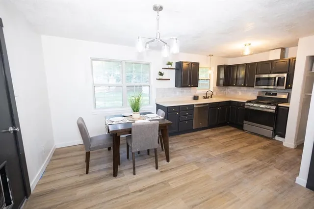 a large kitchen with cabinets table and chairs