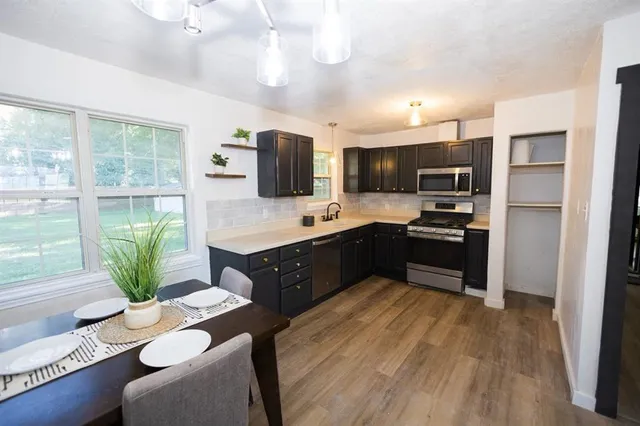 a large kitchen with kitchen island a large counter top space appliances and a ceiling fan