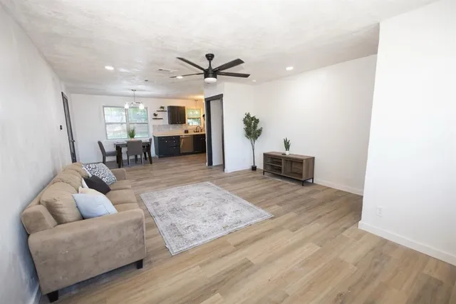 a living room with furniture and a ceiling fan