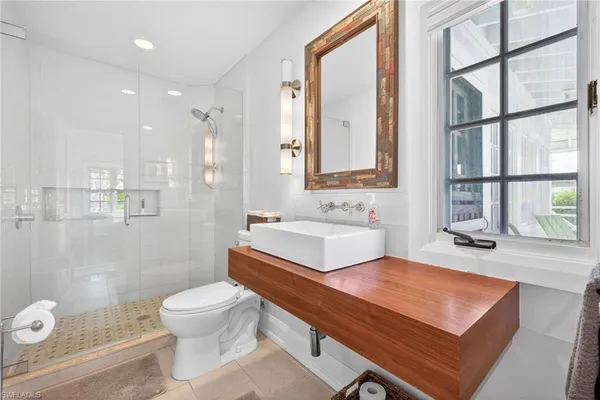 a bathroom with a sink a toilet and shower