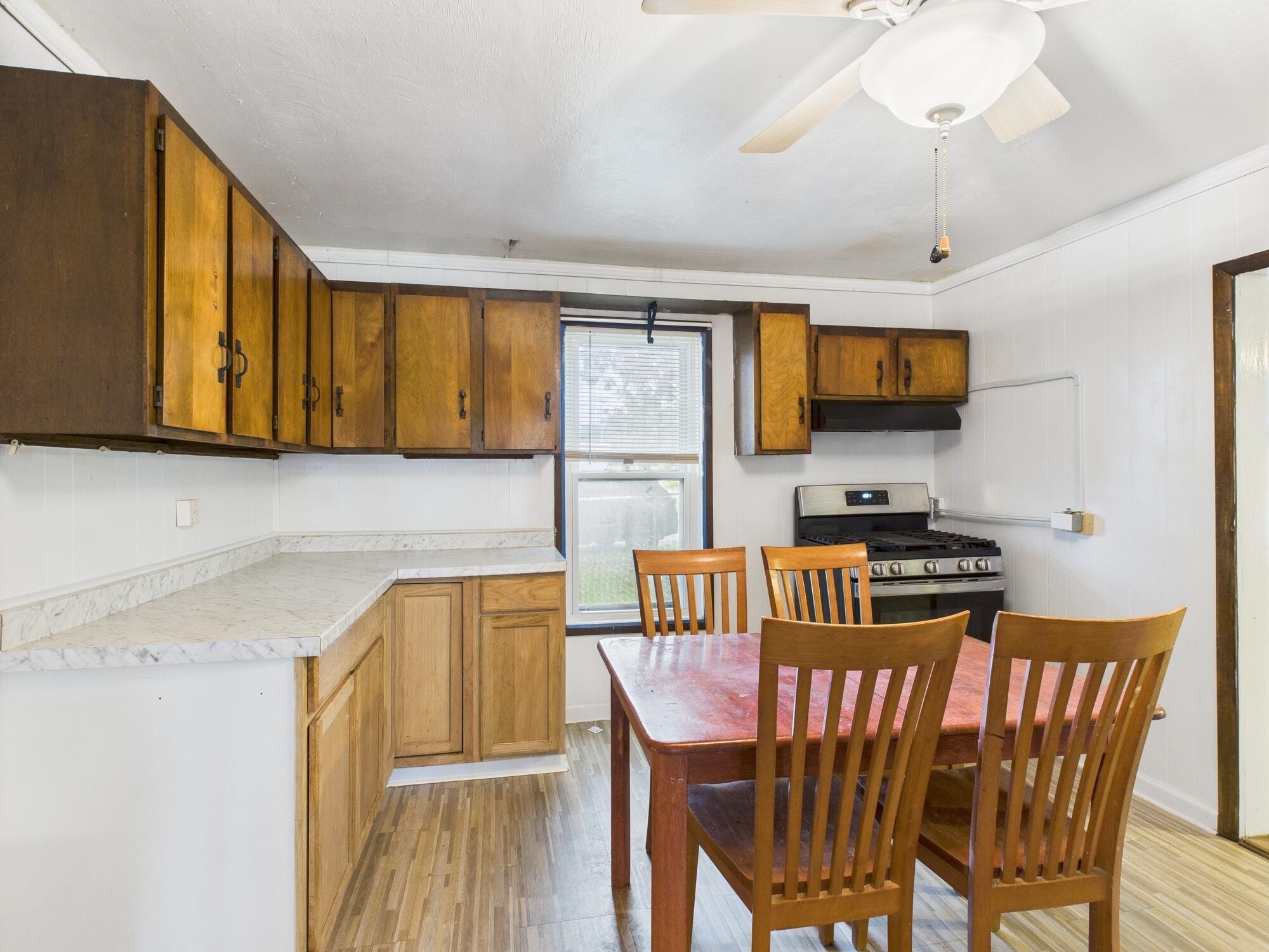 174 East Jackson Avenue Spring City, TN 37381 - Photo 9 of 28 a kitchen with stainless steel appliances granite countertop a stove a sink a microwave a dining table and chairs with wooden floor