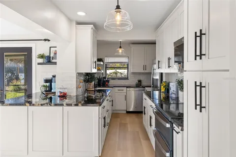 a kitchen with kitchen island granite countertop lots of counter top space and appliances