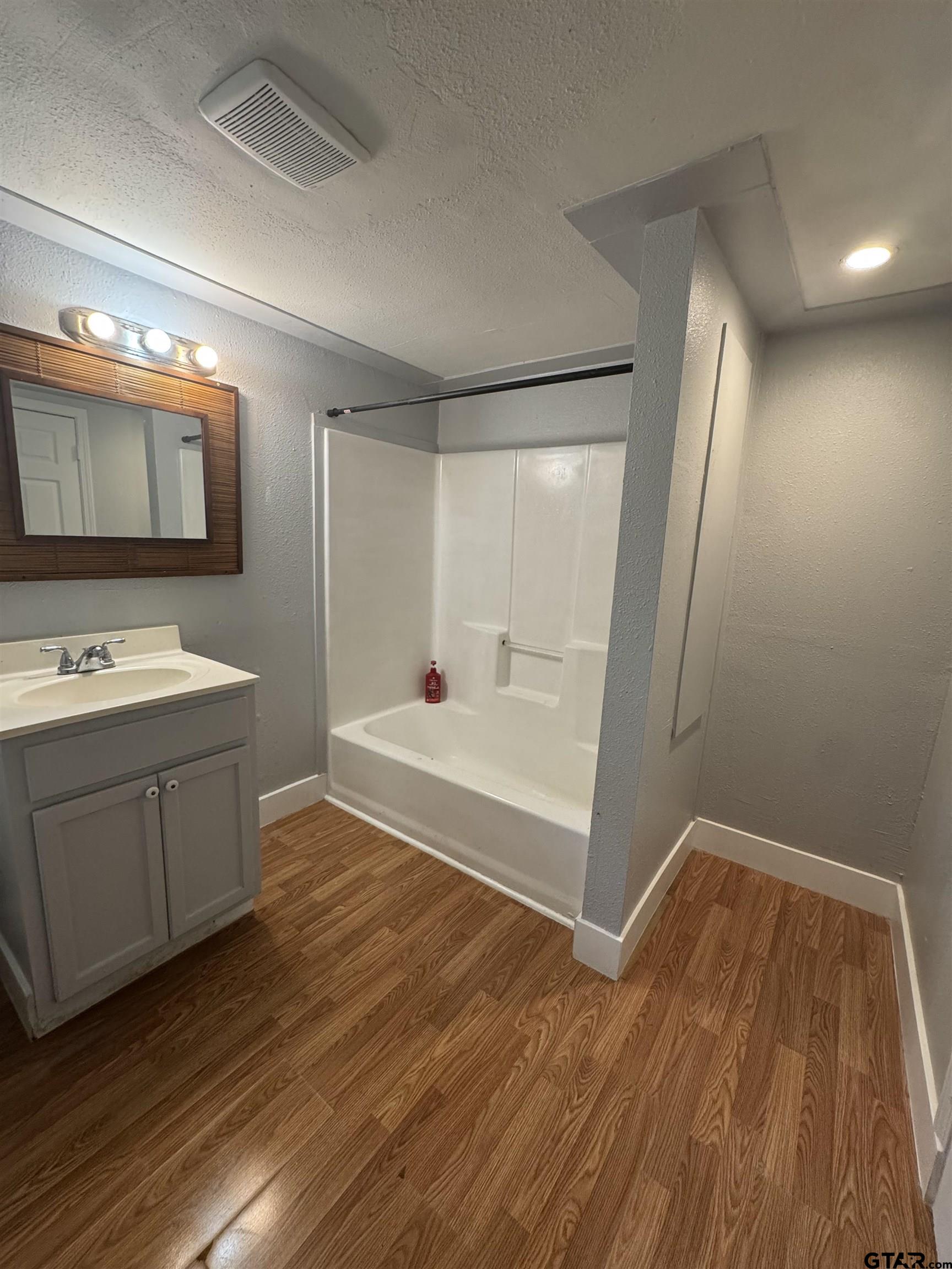 8124 County Road 381 Tyler, TX 75708 - Photo 22 of 23 a bathroom with a sink a mirror and a bathtub