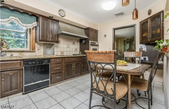 a kitchen with stainless steel appliances kitchen island granite countertop a stove a sink dishwasher and cabinets