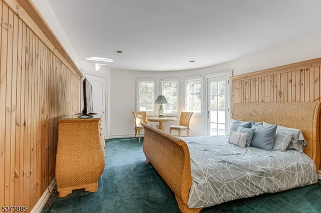 a bedroom with furniture and a large window