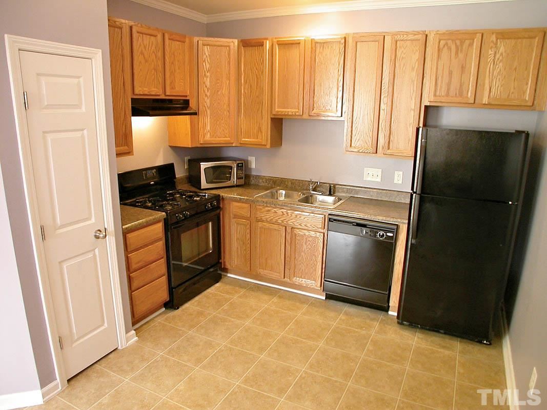 11710 Coppergate Drive, Unit 104 Raleigh, NC 27614 - Photo 5 of 14 a kitchen with a stove a sink and a refrigerator