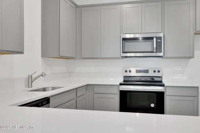 a kitchen with stainless steel appliances granite countertop a stove and a microwave