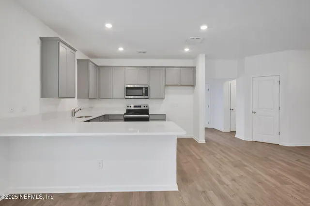 a kitchen with stainless steel appliances a refrigerator sink and microwave