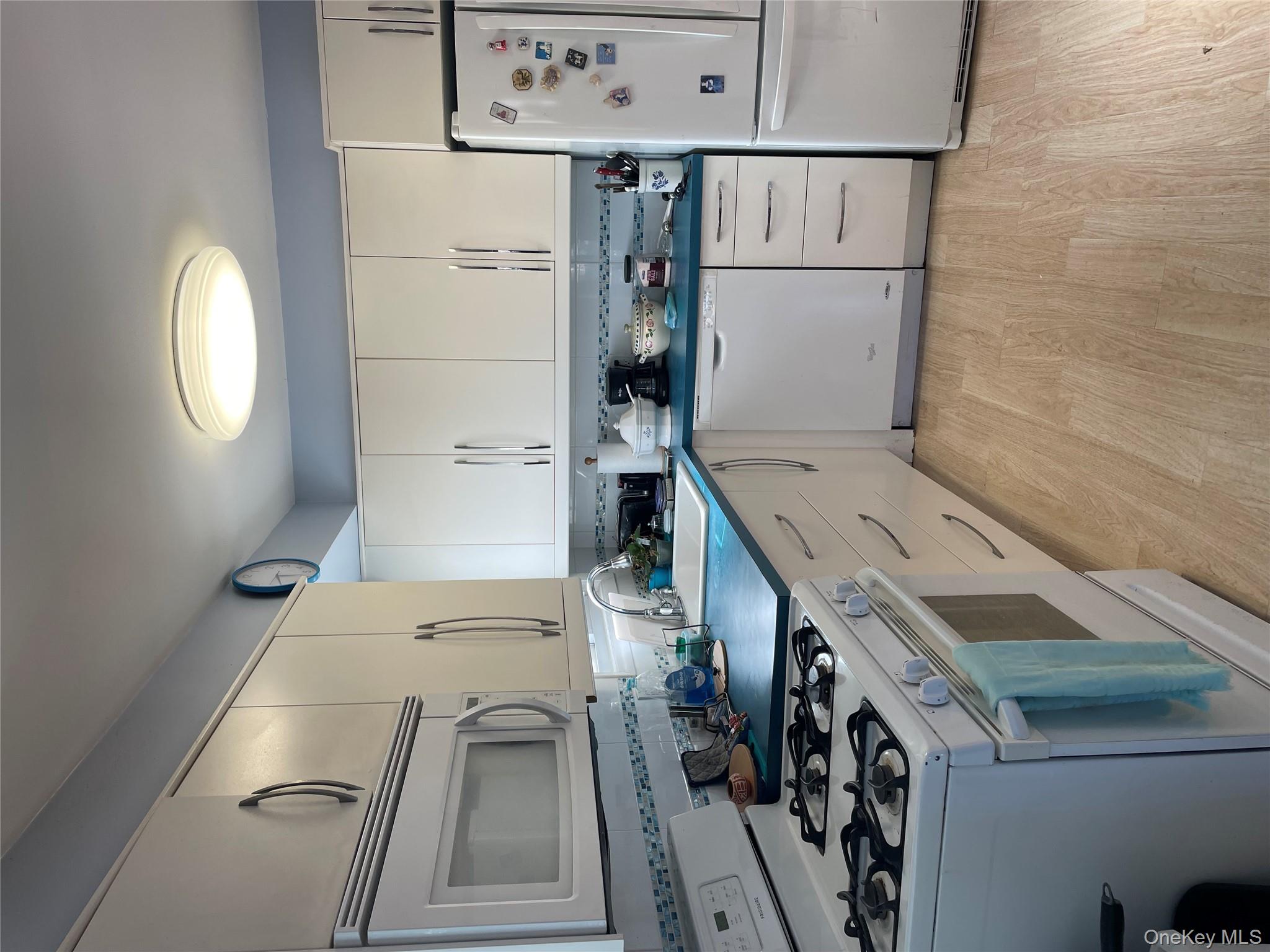 154-58 20th Road Queens, NY 11357 - Photo 4 of 27 a kitchen with granite countertop white cabinets and white appliances