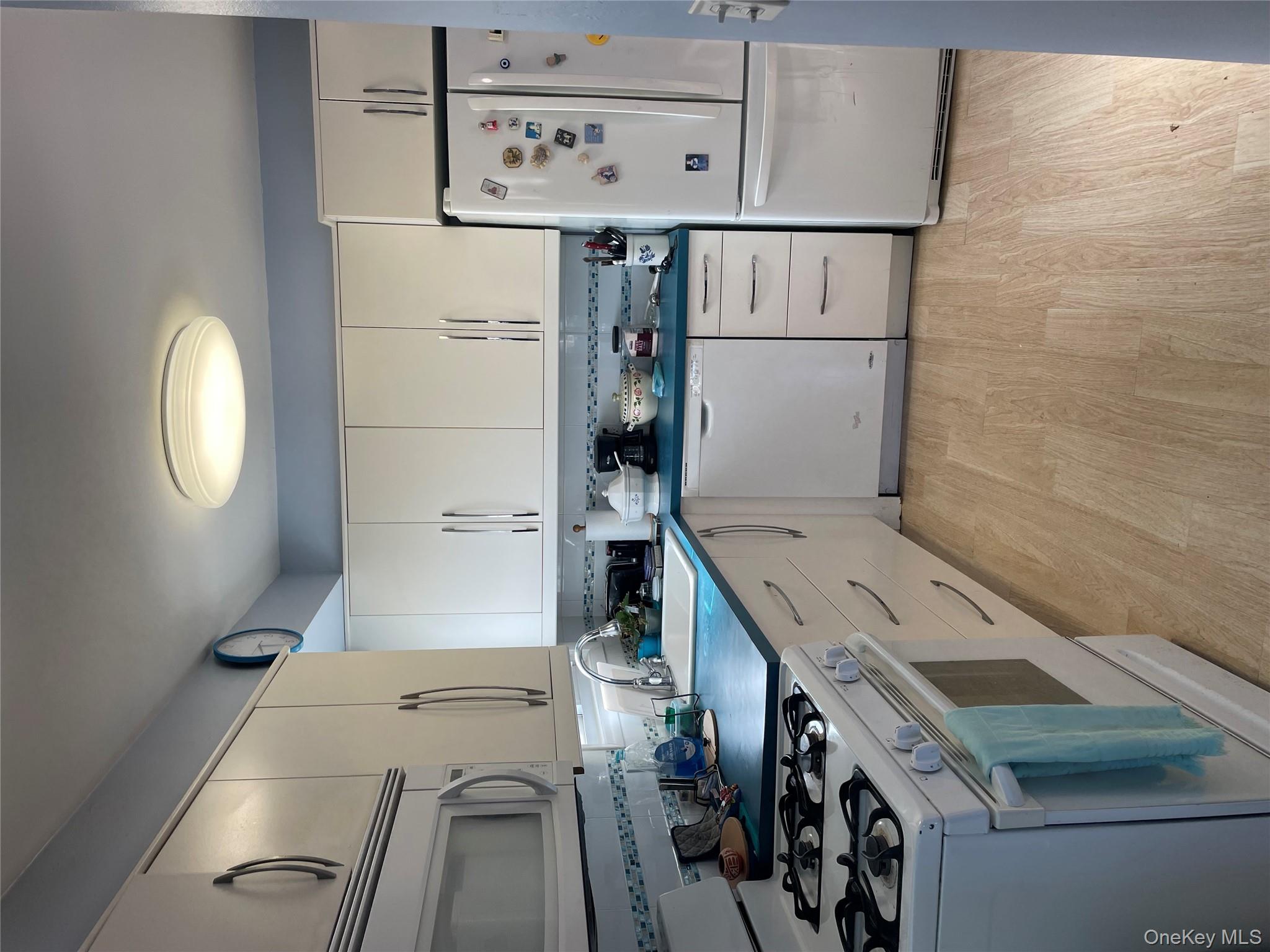 154-58 20th Road Queens, NY 11357 - Photo 5 of 27 a kitchen with granite countertop a refrigerator stove and white cabinets