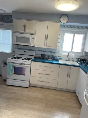 a kitchen with granite countertop a stove a sink and a wooden cabinets