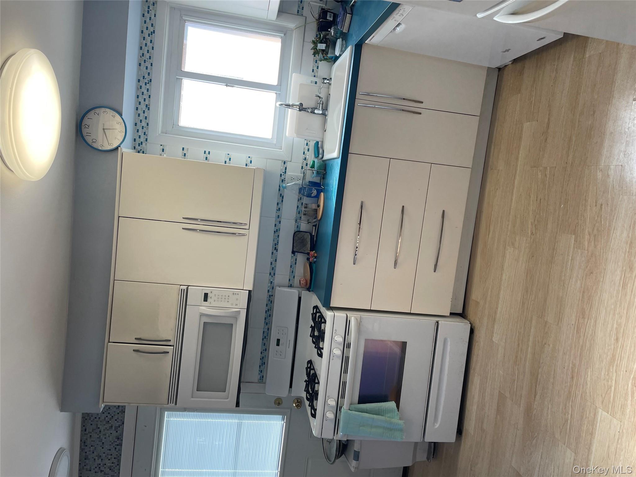 154-58 20th Road Queens, NY 11357 - Photo 6 of 27 a kitchen with granite countertop a stove a sink and a wooden cabinets