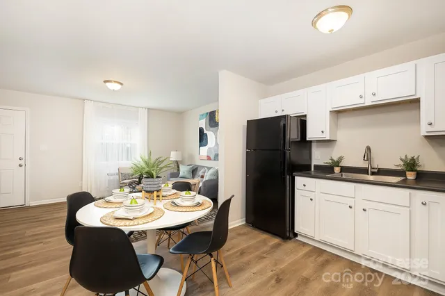 a kitchen with stainless steel appliances kitchen island granite countertop a sink refrigerator and cabinets