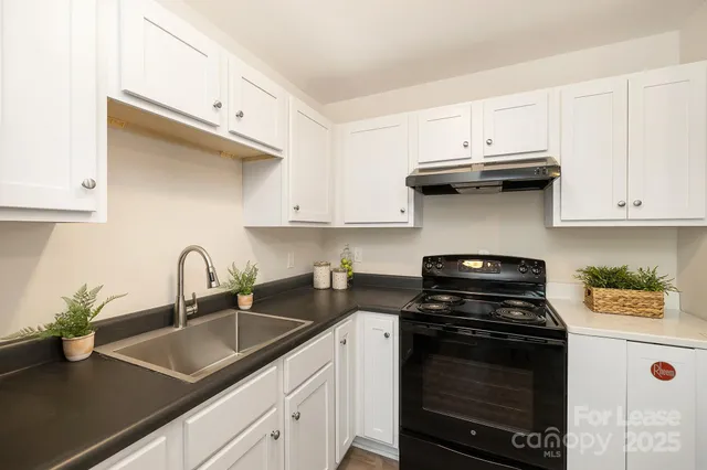 a kitchen with stainless steel appliances granite countertop a sink stove and cabinets