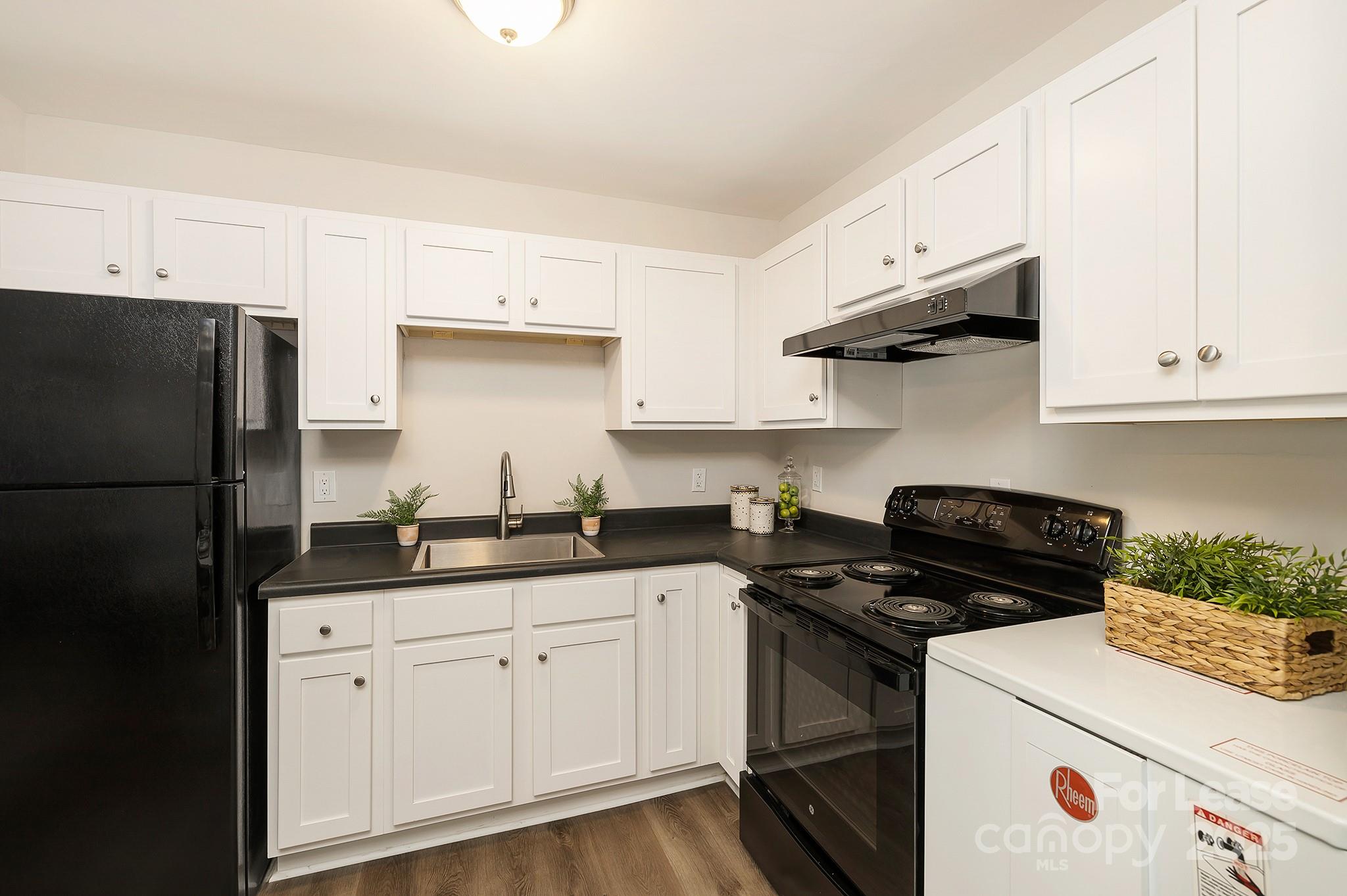 1850 Lowell Bethesda Road, Unit 2 Gastonia, NC 28056 - Photo 7 of 13 a kitchen with a sink dishwasher a refrigerator a stove and white cabinets