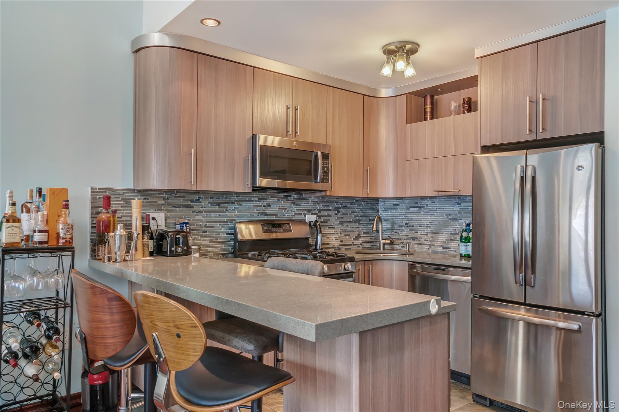208 Beach 124th Street, Unit 6 Queens, NY 11694 - Photo 11 of 16 a kitchen with stainless steel appliances granite countertop a refrigerator a stove a sink and a microwave