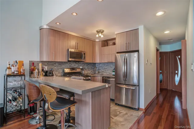 a kitchen with granite countertop a refrigerator and a stove top oven