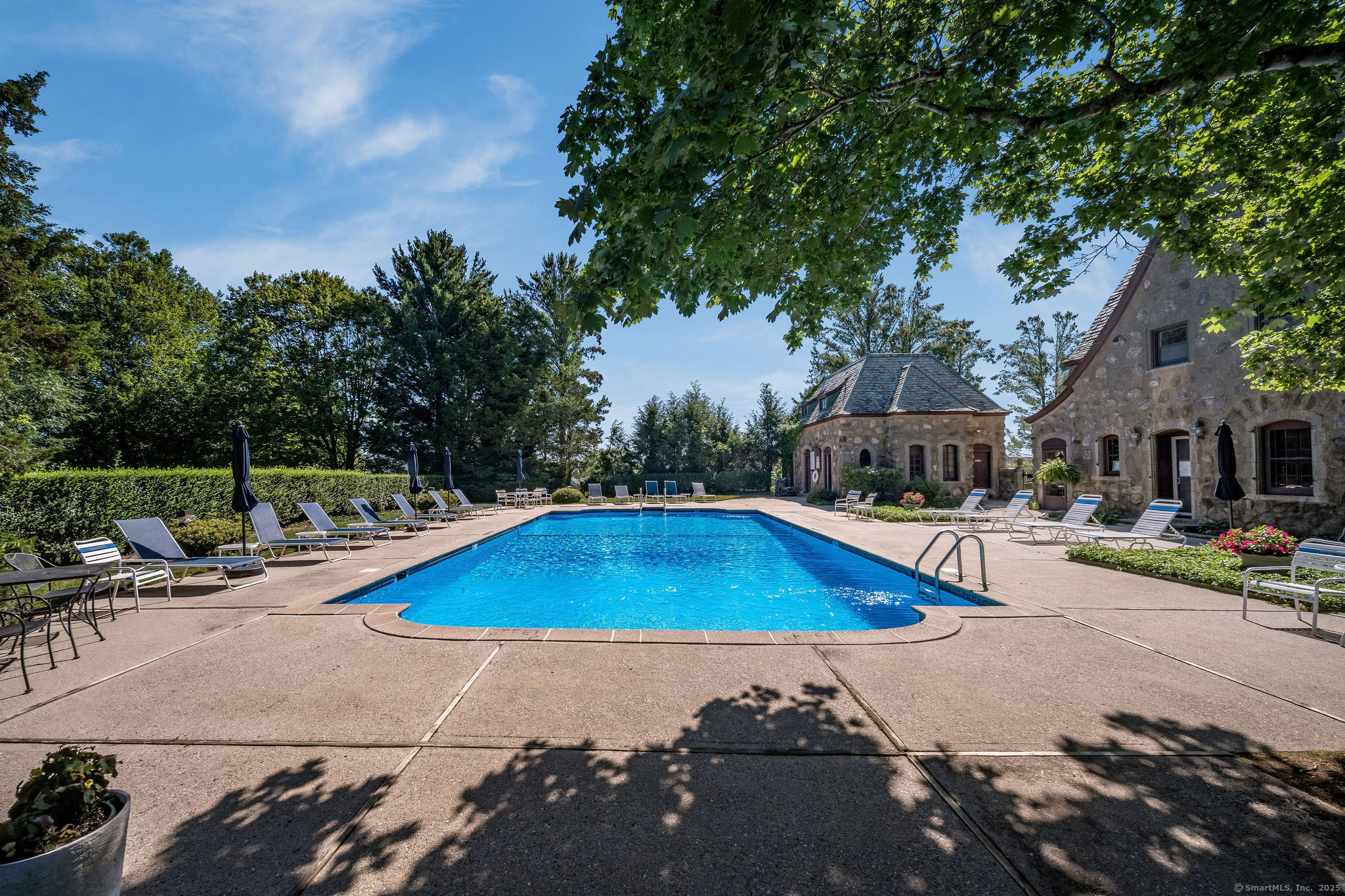 40 Legend Hill Road, Unit 40 Madison, CT 06443 - Photo 2 of 29 a view of a swimming pool with lawn chairs under an umbrella