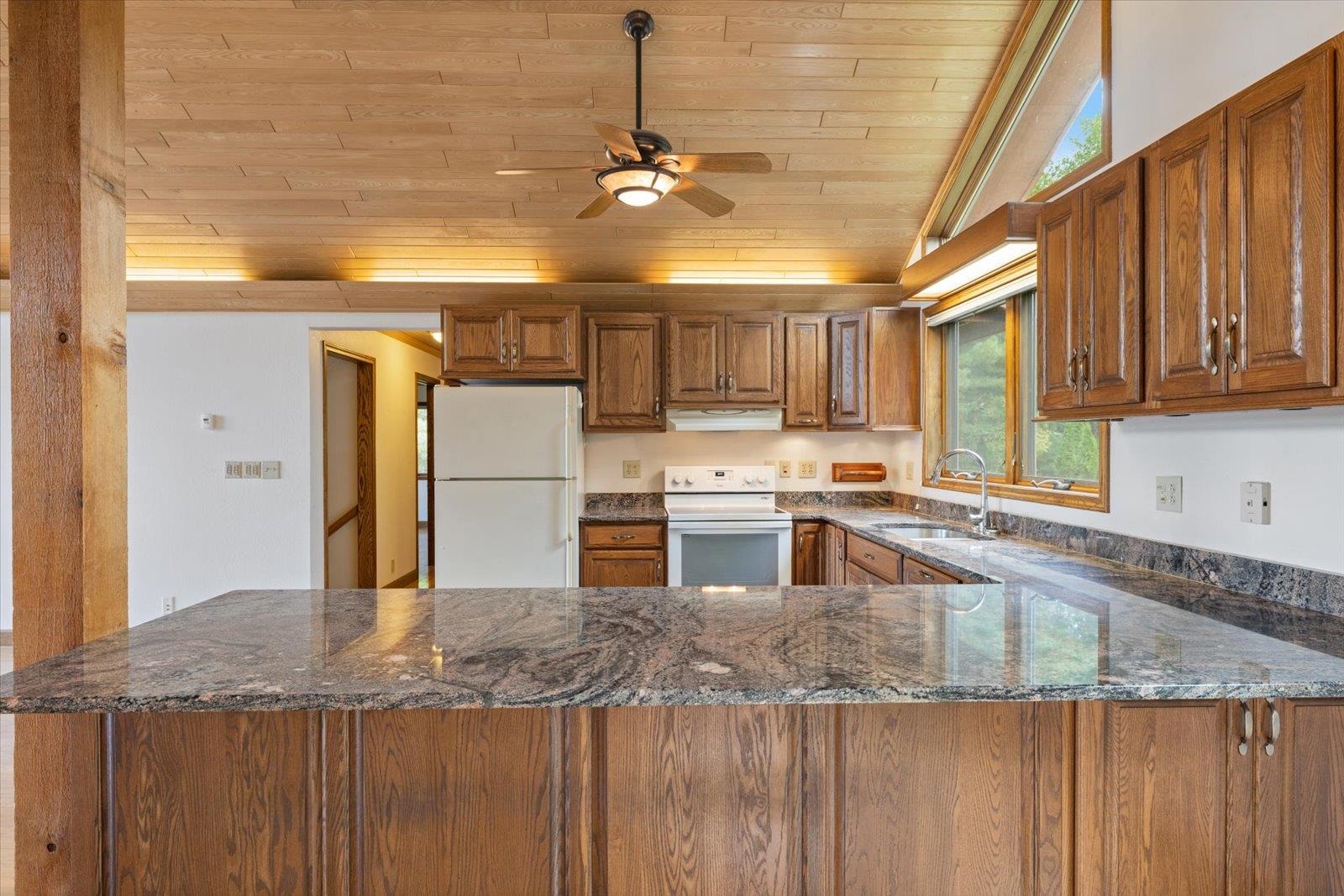 2375 Viste Point Road Ely, MN 55731 - Photo 23 of 83 Kitchen featuring stone counters, vaulted wooden ceiling, wood cabinetry, and ceiling fan