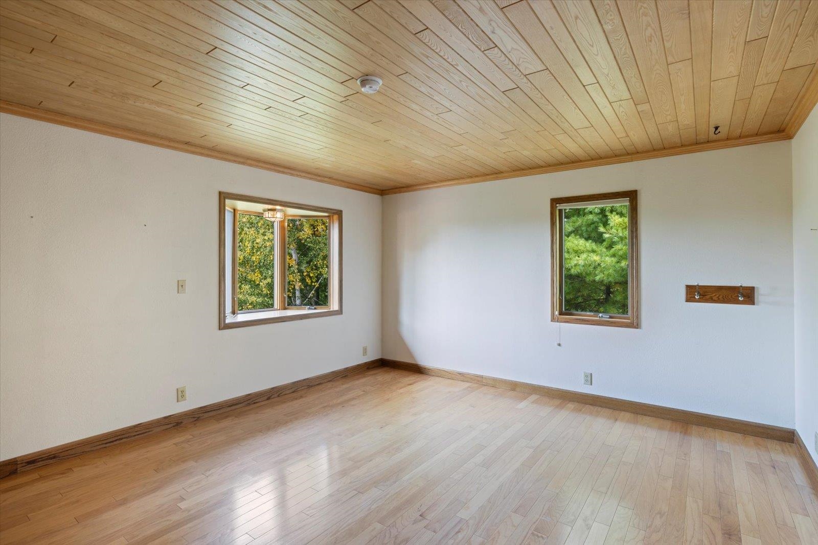 2375 Viste Point Road Ely, MN 55731 - Photo 26 of 83 Primary bedroom featuring light wood flooring, and wooden ceiling. Room is situated on the lake side and also has a bay window.