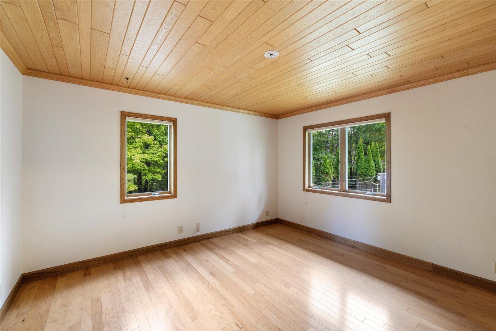 2375 Viste Point Road Ely, MN 55731 - Photo 27 of 83 Unfurnished bedroom featuring crown molding, light wood floors, and wood ceiling