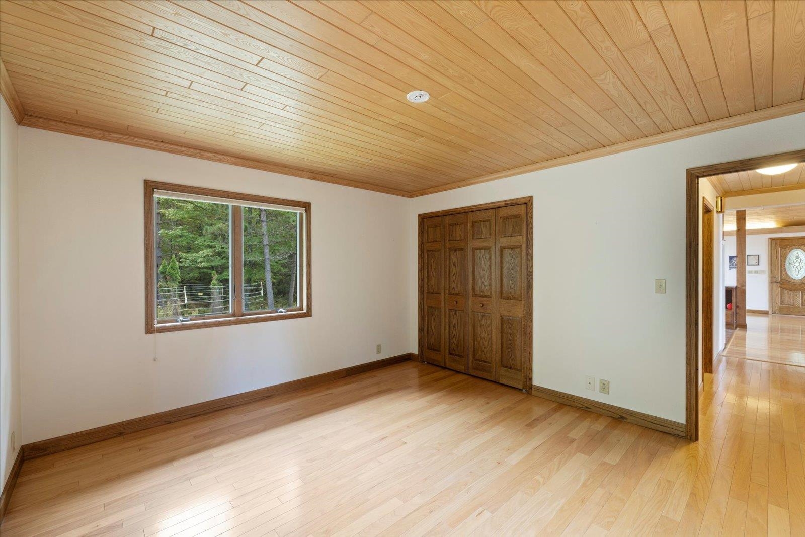 2375 Viste Point Road Ely, MN 55731 - Photo 28 of 83 Unfurnished bedroom featuring light wood finished floors, wooden ceiling, crown molding, and a closet
