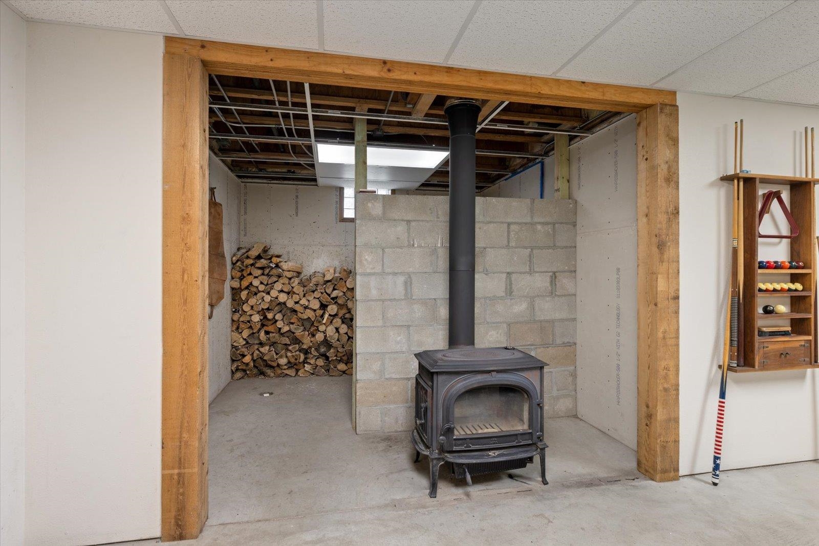 2375 Viste Point Road Ely, MN 55731 - Photo 35 of 83 Below grade area featuring a wood stove and a wood storage area