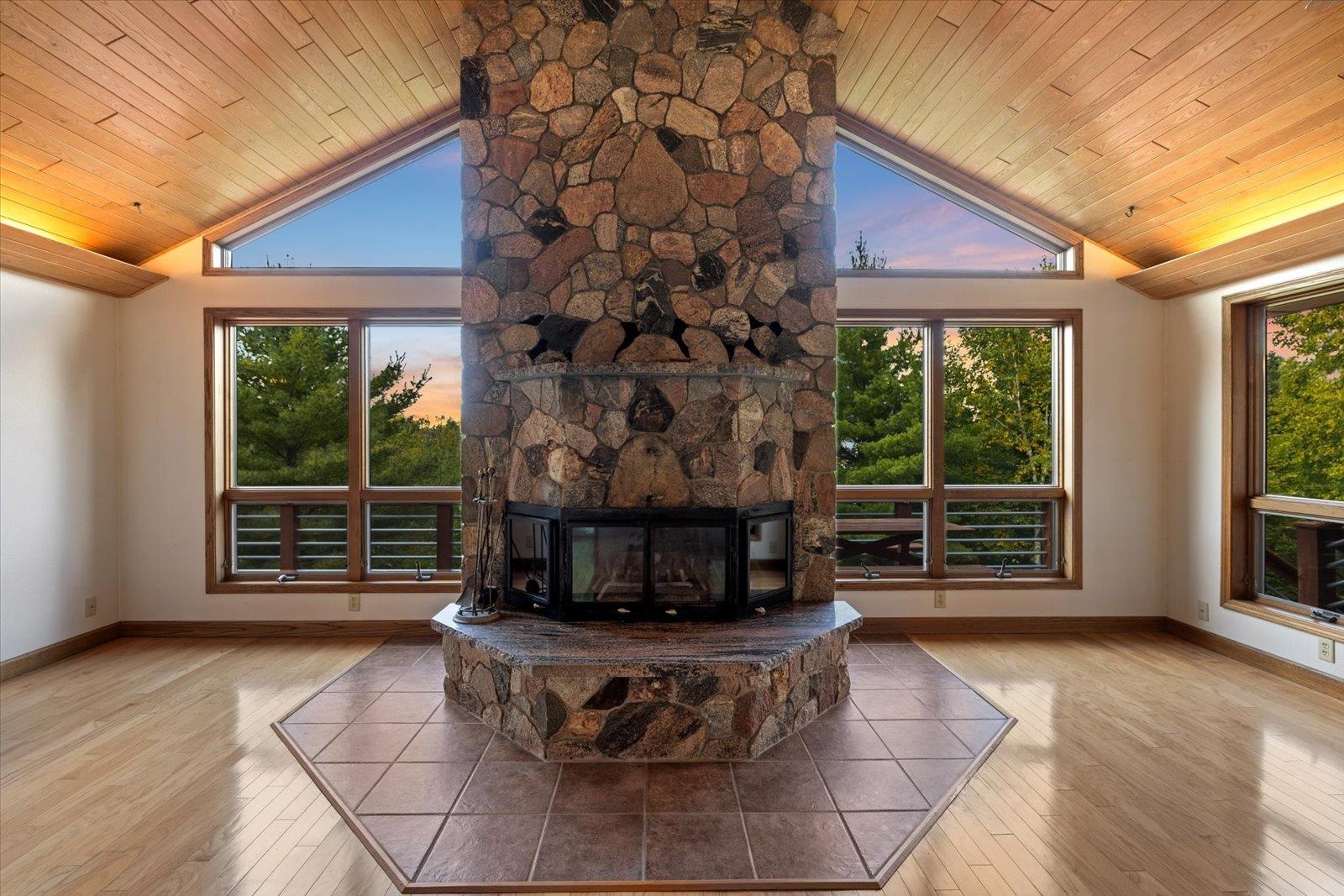 2375 Viste Point Road Ely, MN 55731 - Photo 5 of 83 Living room with light wood flooring, plenty of natural light, stone fireplace, high vaulted ceiling, and wooden ceiling