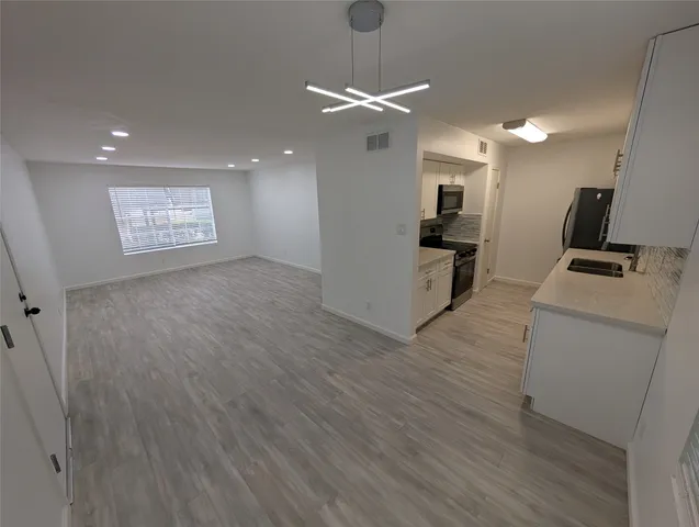 a view of a room with wooden floor and a ceiling fan