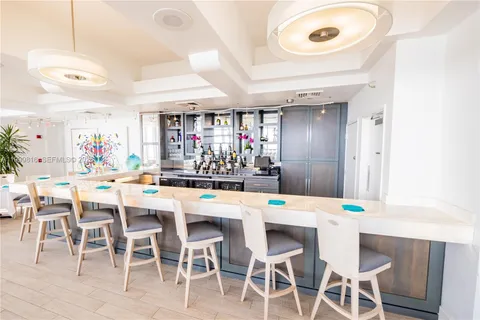 a dining area with a table chairs and a kitchen view