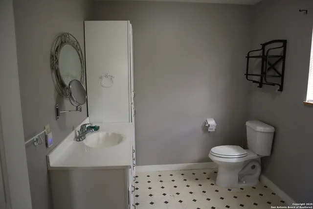 a bathroom with a sink toilet and a mirror